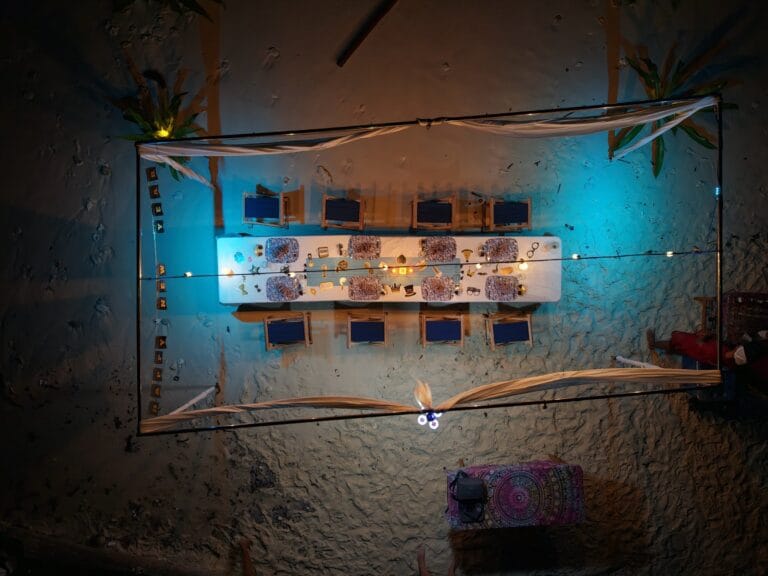 Aerial view of a candlelit beach dinner set up for Tiger Blue guests