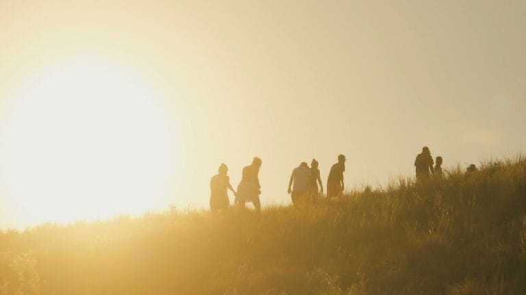 Guests hiking a Komodo hillside at golden hour