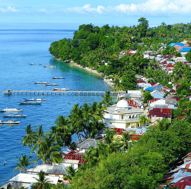 Colourful boats and houses along the harbour of Banda Neira in the Banda Islands