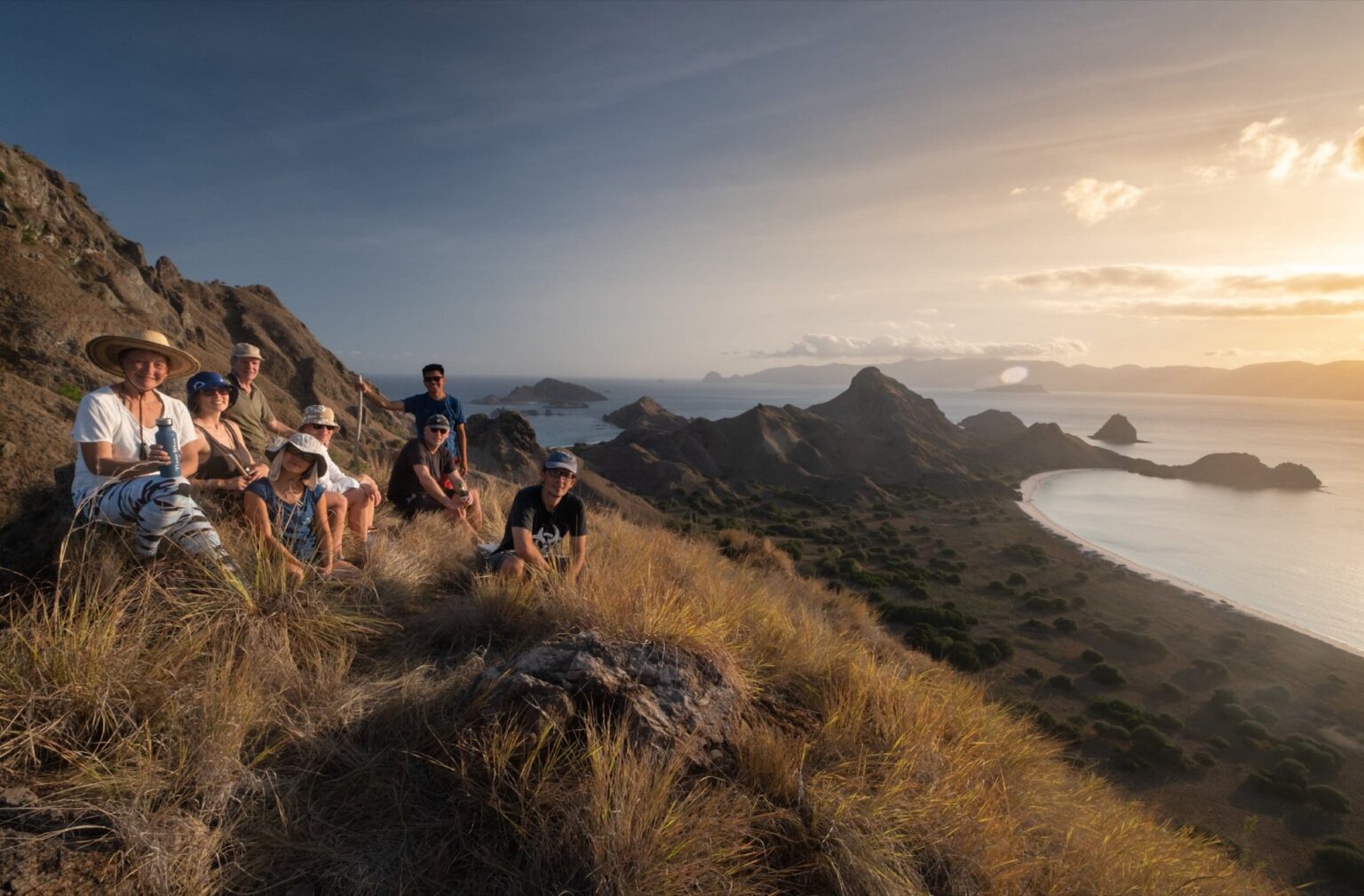 Guests resting on a hilltop above Komodo's bays at sunset
